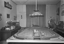 836636 Afbeelding van de heer H. de Groot bij zijn modelspoorbaan in de woonkamer van zijn huis aan de Justus van ...